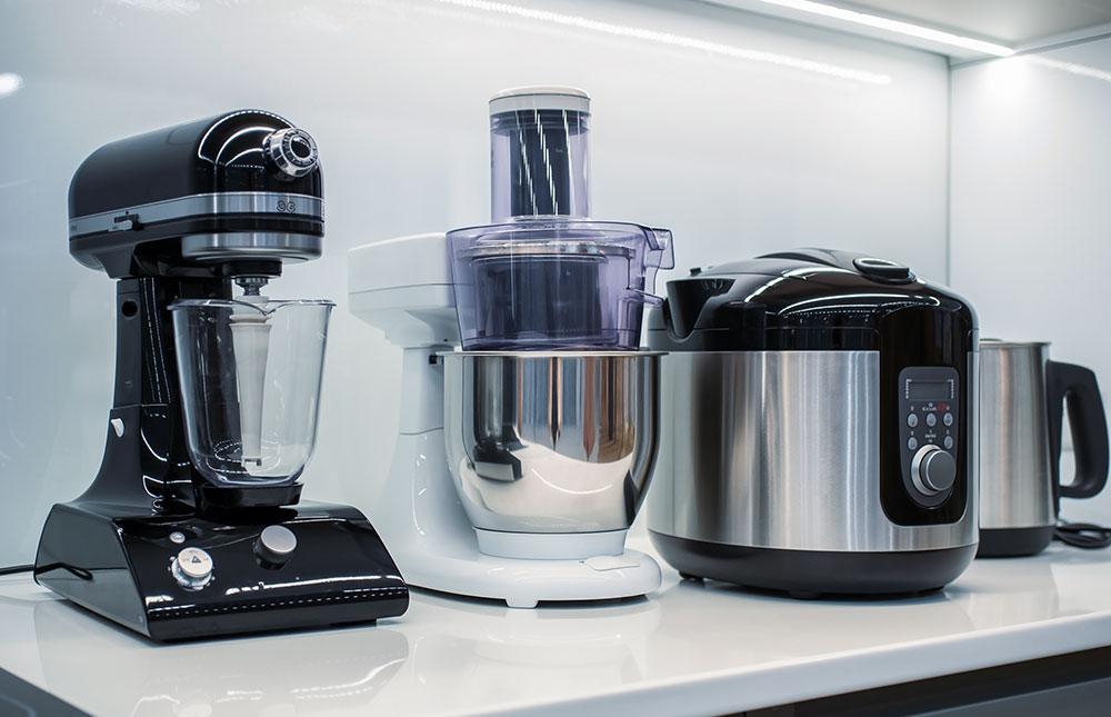 A kitchen items at the Numaish exhibition featuring a blender, mixer, and food processor on a countertop.